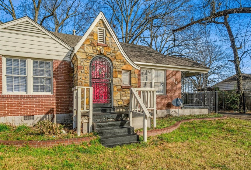 Tudor-style house with brick siding, a shingled roof, and crawl space