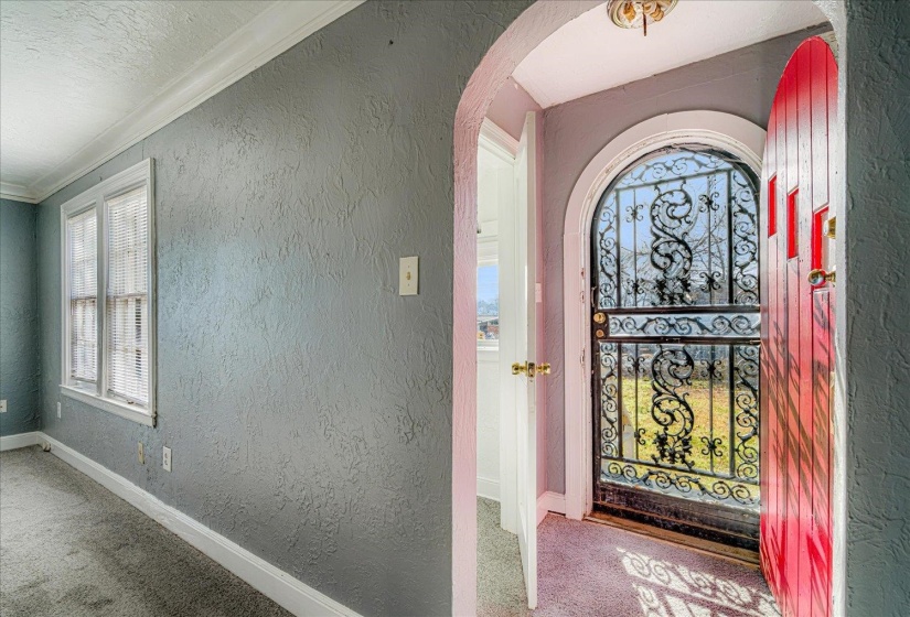 Entryway with a textured wall, carpet, a textured ceiling, arched walkways, and crown molding