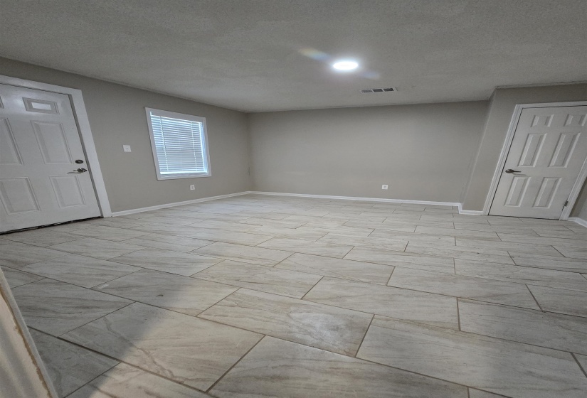 Basement with baseboards and a textured ceiling