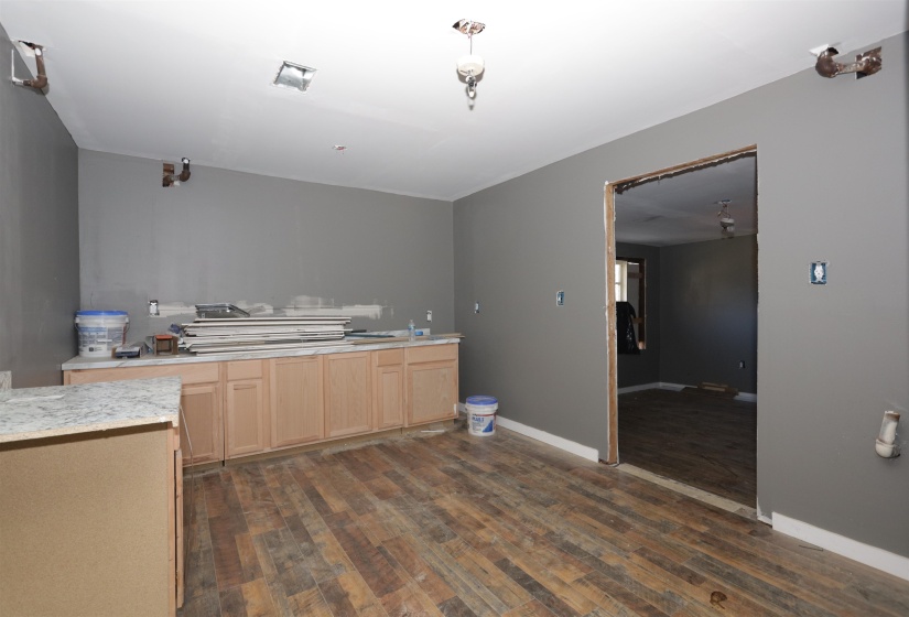 Kitchen featuring light wood finish cabinetry, light countertops, and dark wood-style floors