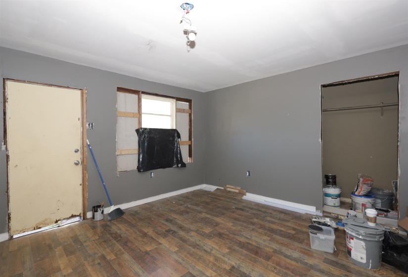 Unfurnished bedroom with dark wood-type flooring and baseboards