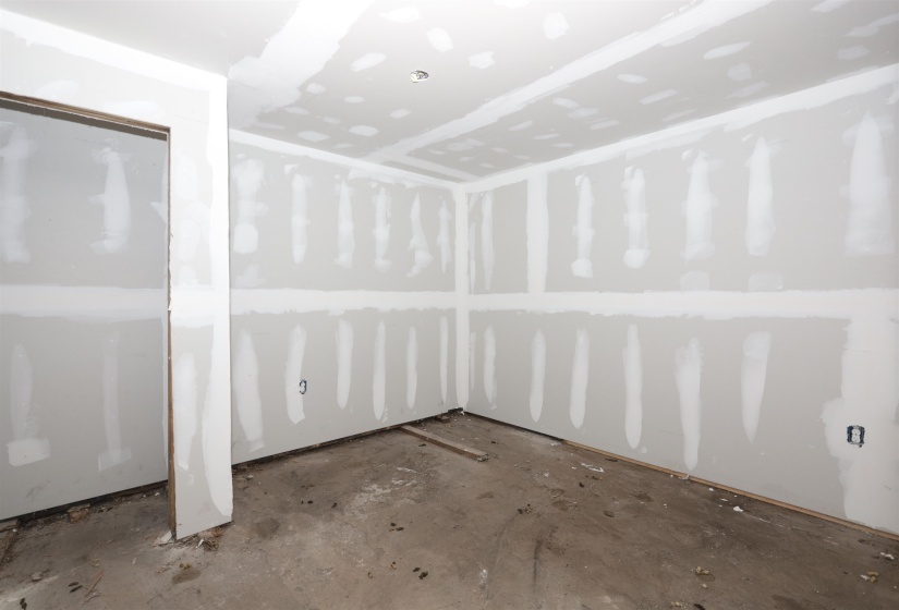 Empty room featuring unfinished concrete flooring