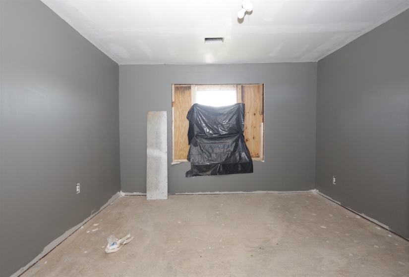 Empty room featuring unfinished concrete flooring