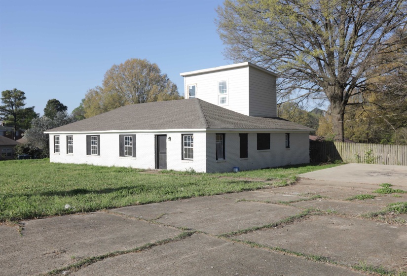 View of front facade with a shingled roof and brick siding