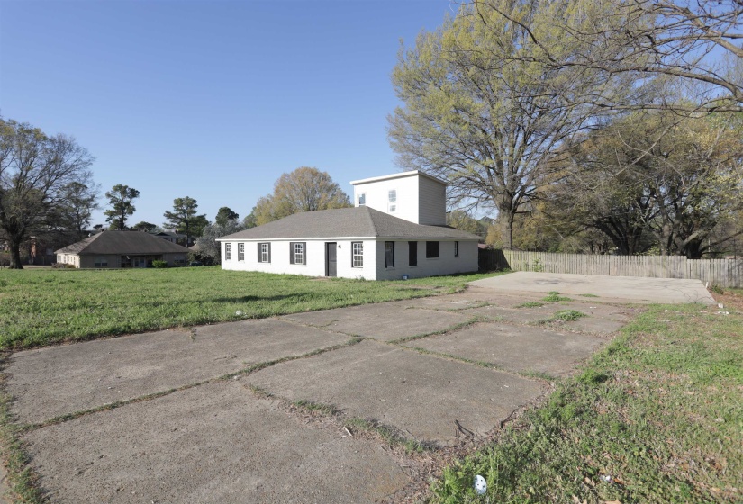 Rear view of property with concrete driveway and roof with shingles