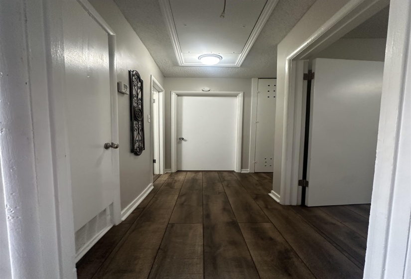 Hallway featuring attic access and dark wood-type flooring