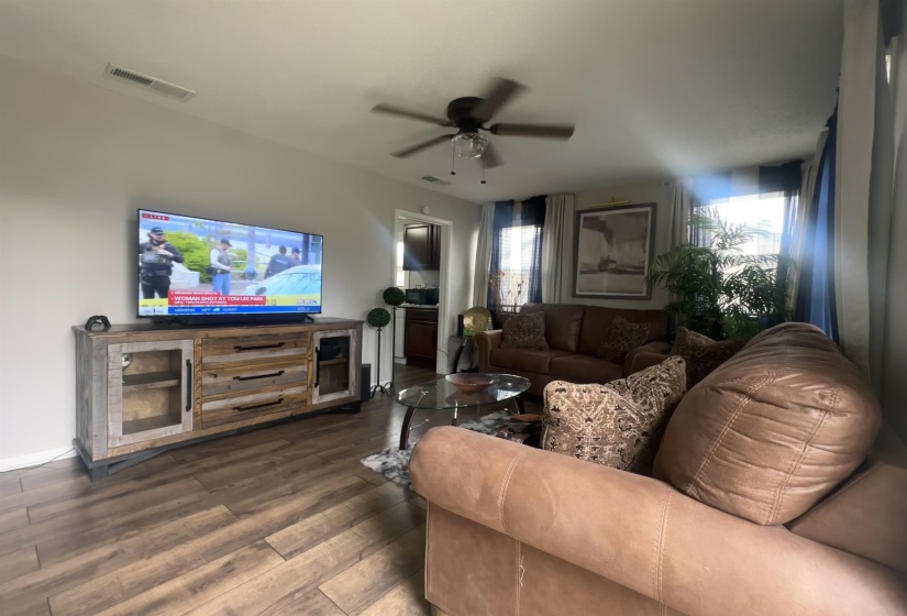 Living room with dark wood-style floors and ceiling fan