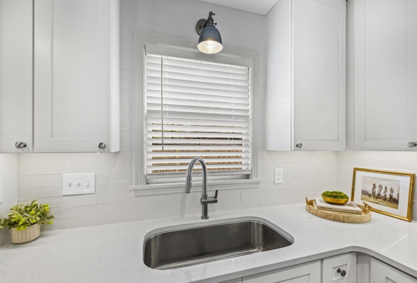 Kitchen with light stone countertops and white cabinets