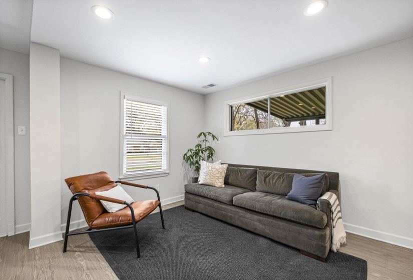 Living room with light wood-style flooring and recessed lighting