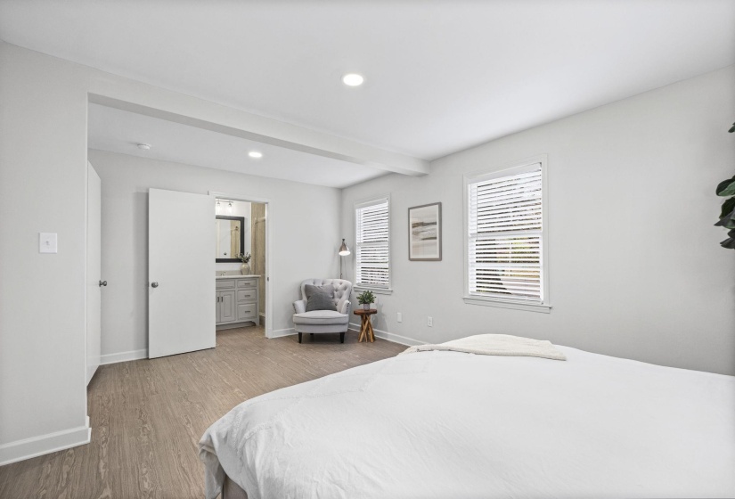 Bedroom featuring wood finished floors, recessed lighting, connected bathroom, and beamed ceiling