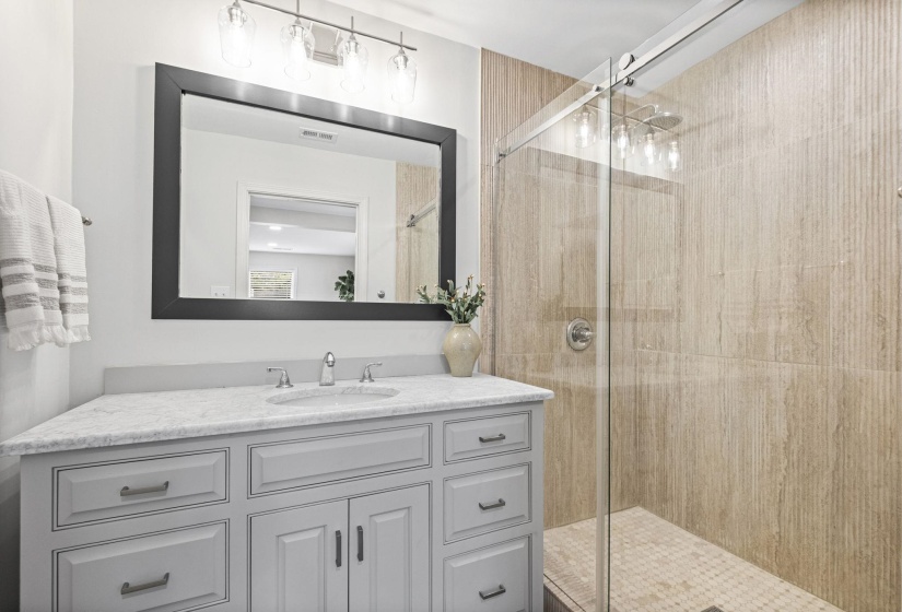 Bathroom featuring vanity and a shower stall