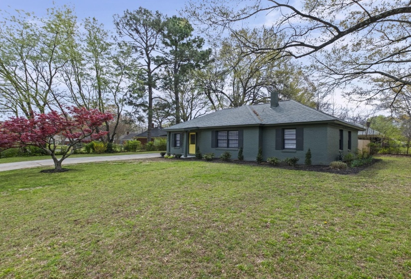 View of property exterior with brick siding, a chimney, and roof with shingles