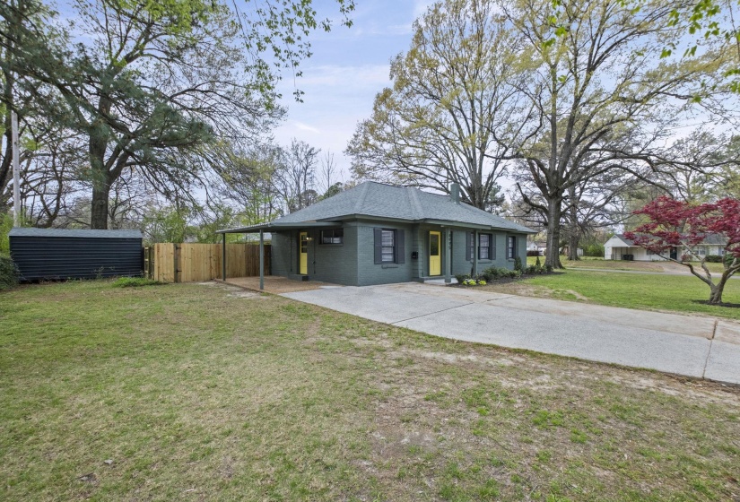 View of front of property featuring an attached carport, driveway, and brick siding