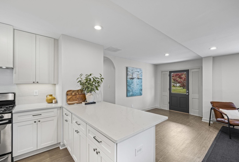 Kitchen with stainless steel range with gas stovetop, light stone countertops, dark wood-style floors, a peninsula, and recessed lighting
