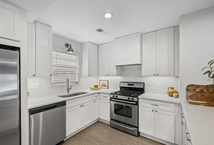 Kitchen featuring stainless steel appliances, white cabinets, dark wood-type flooring, and recessed lighting