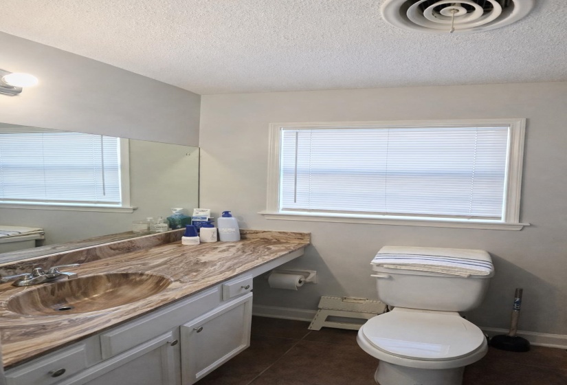 Bathroom featuring vanity, a textured ceiling, and dark tile patterned flooring