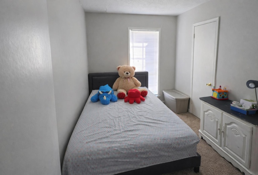 Bedroom featuring light carpet and a textured ceiling