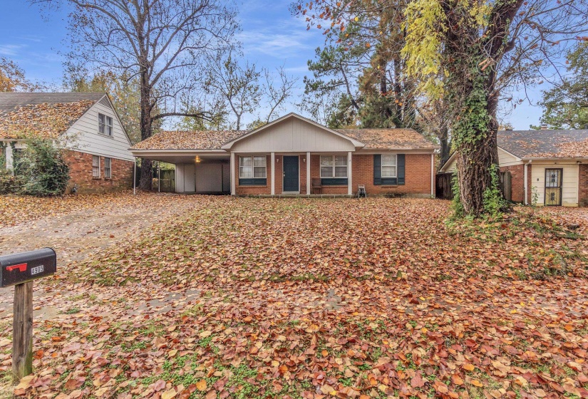 Ranch-style home with brick siding, a carport, driveway, and a porch