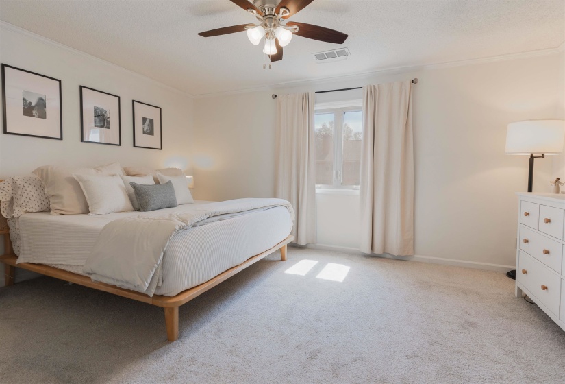 Bedroom featuring light colored carpet, a ceiling fan, and ornamental molding