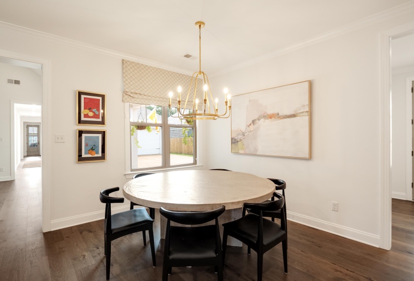 Dining area featuring crown molding, dark wood finished floors, and a chandelier