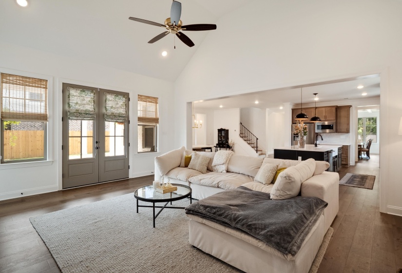Living room with recessed lighting, dark wood-style floors, ceiling fan, french doors, and lofted ceiling