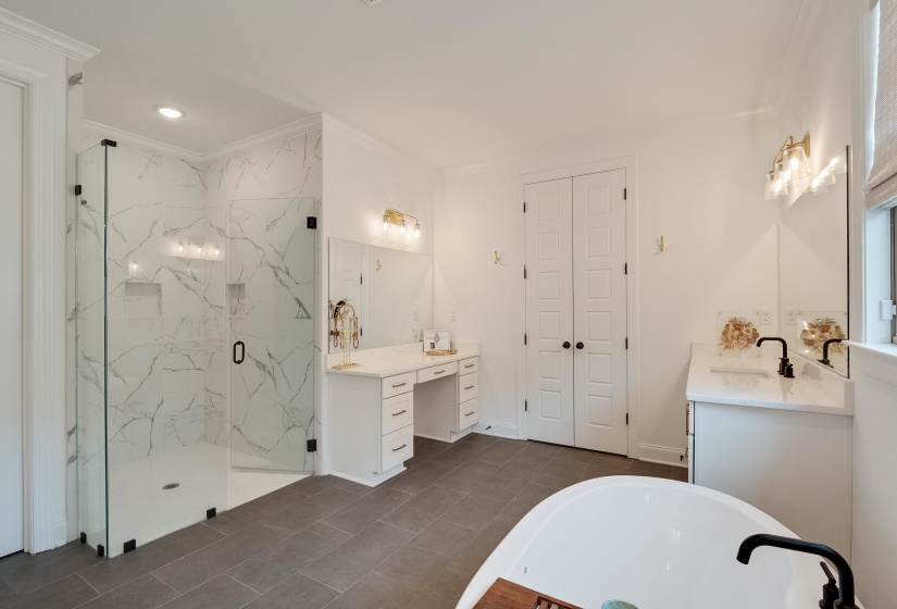Bathroom featuring two vanities, a marble finish shower, ornamental molding, a bathtub, and recessed lighting