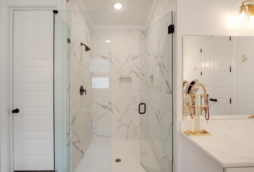 Bathroom featuring ornamental molding, a marble finish shower, and recessed lighting