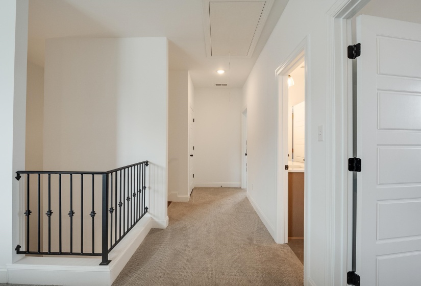Corridor with an upstairs landing, light colored carpet, and recessed lighting