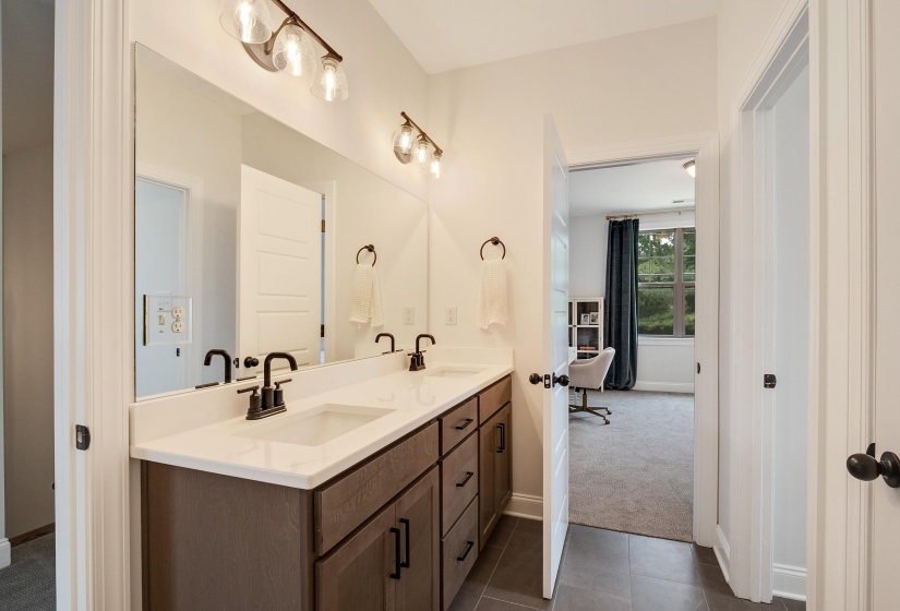 Full bathroom featuring double vanity, dark tile patterned flooring, and dark carpet