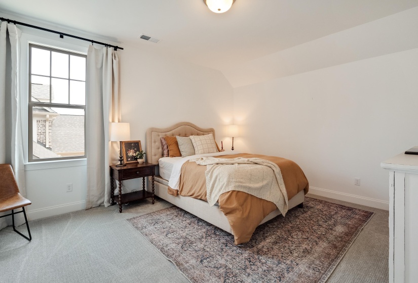 Bedroom featuring light carpet and lofted ceiling