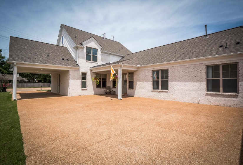 Rear view of property featuring a shingled roof, a patio area, and brick siding
