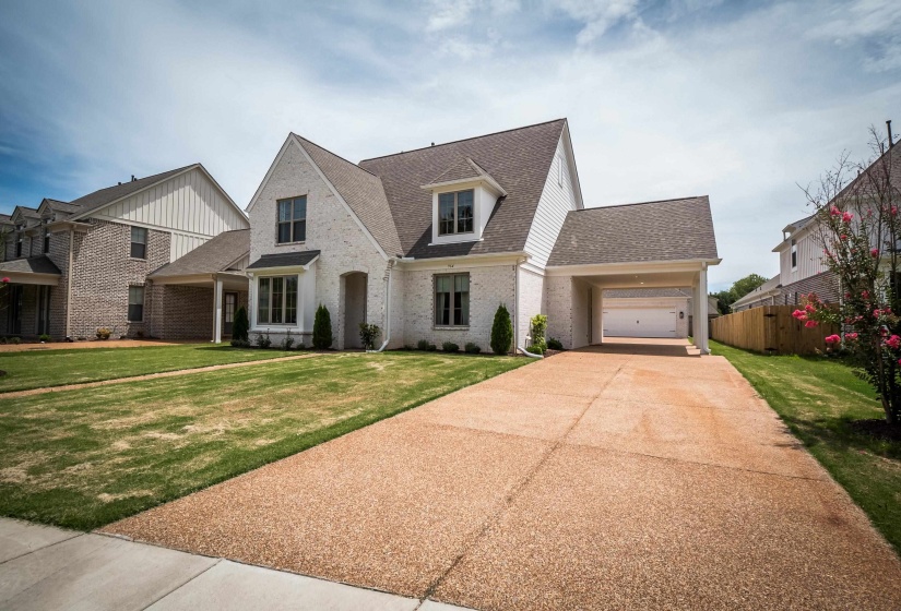 View of front of property with a shingled roof, brick siding, and concrete driveway