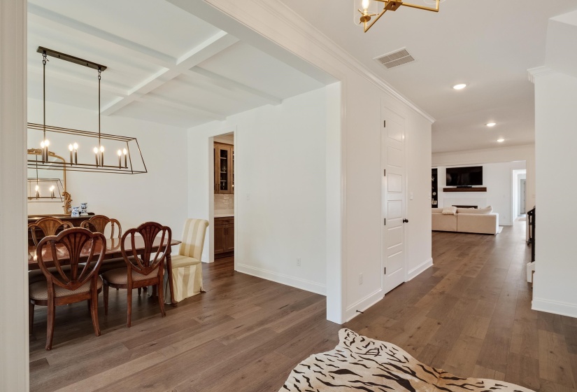 Dining area featuring suspended lighting, dark wood-style flooring, and coffered ceiling