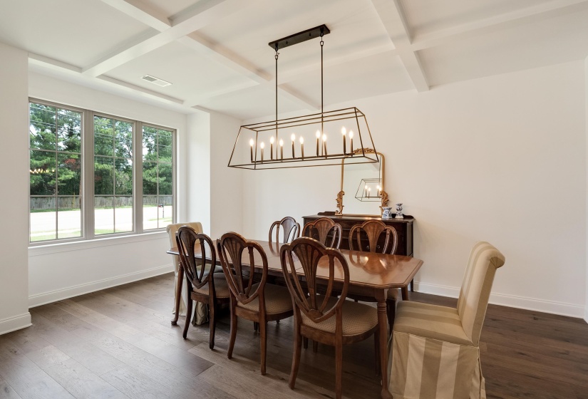 Dining area with coffered ceiling, hanging lights, and hardwood / wood-style flooring