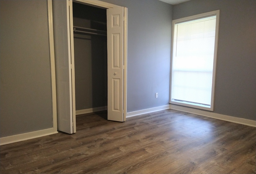 Primary bedroom featuring dark wood finished floors and a closet