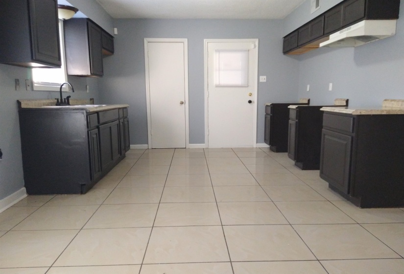 Kitchen with light countertops and light tile patterned flooring