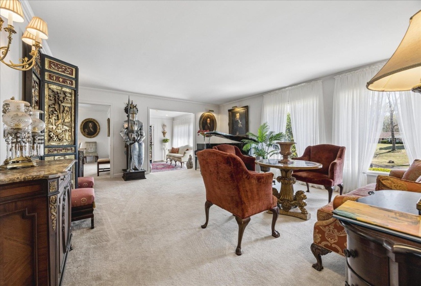 Living area featuring light carpet and ornamental molding