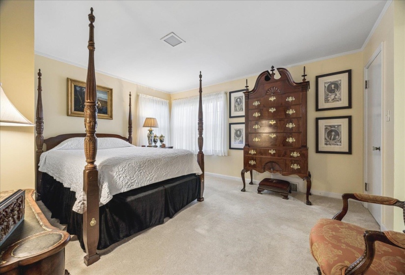 Carpeted bedroom featuring crown molding and baseboards