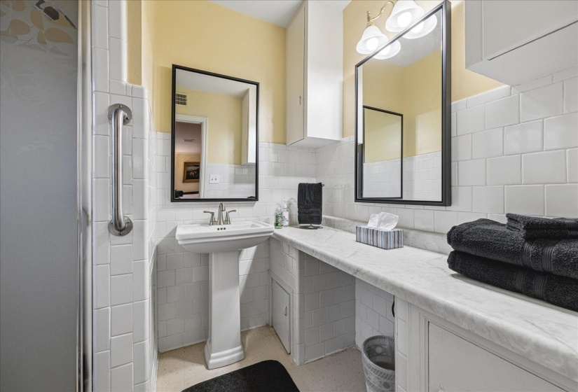 Bathroom with tile walls, a stall shower, and wainscoting