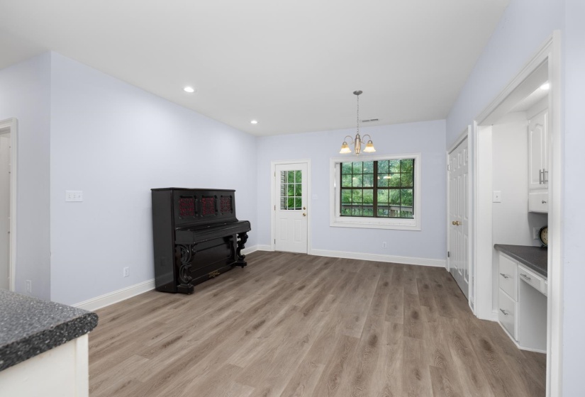 Unfurnished dining area with suspended lighting and light wood-style flooring