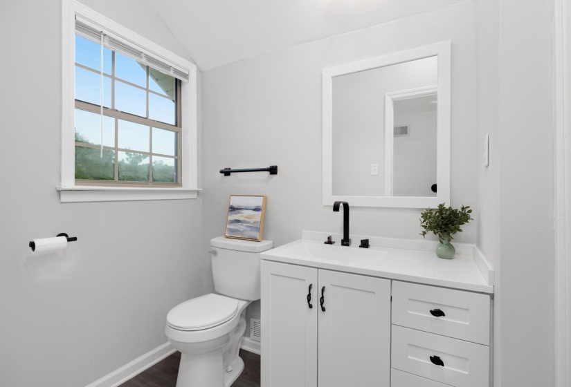 Bathroom featuring vanity, vaulted ceiling, and dark wood-type flooring