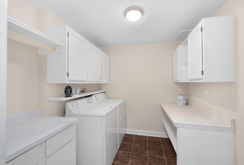 Laundry room featuring separate washer and dryer, a textured ceiling, and cabinet space
