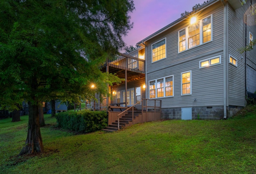 Back of house at dusk featuring a lawn, a wooden deck, and crawl space