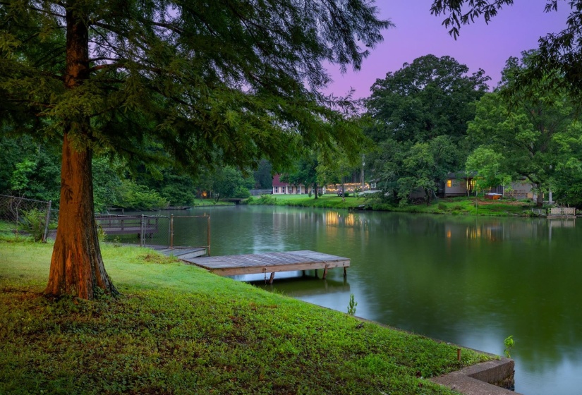 Dock area with a water view and view of wooded area
