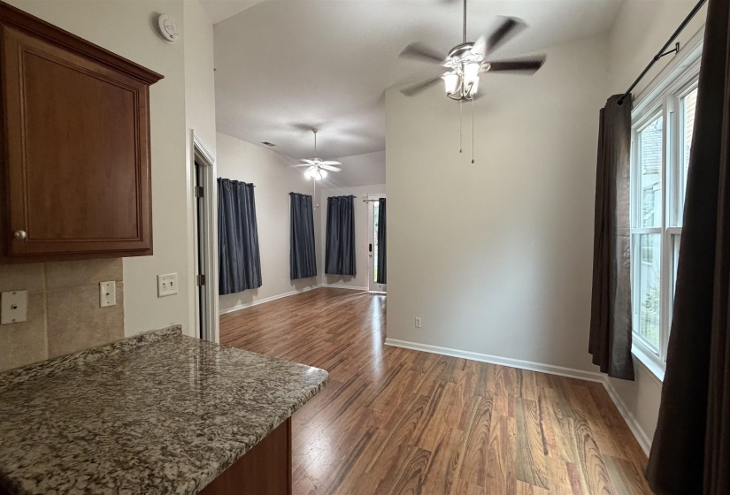 Vaulted ceiling bedroom featuring textured accent wall, ceiling fan with integrated lighting, and carpeted flooring