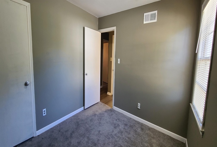 Unfurnished bedroom with carpet flooring and multiple windows
