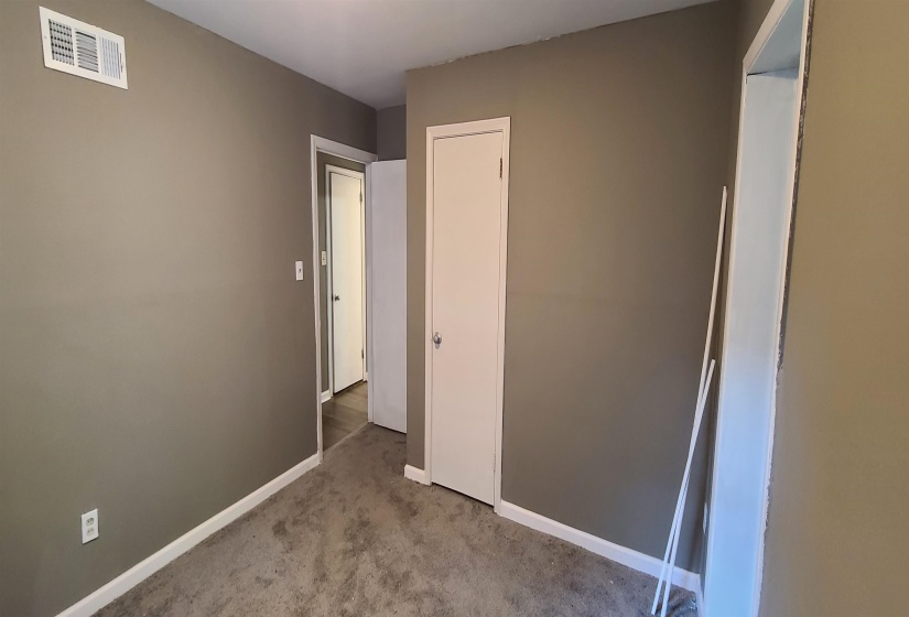 Unfurnished bedroom with light colored carpet