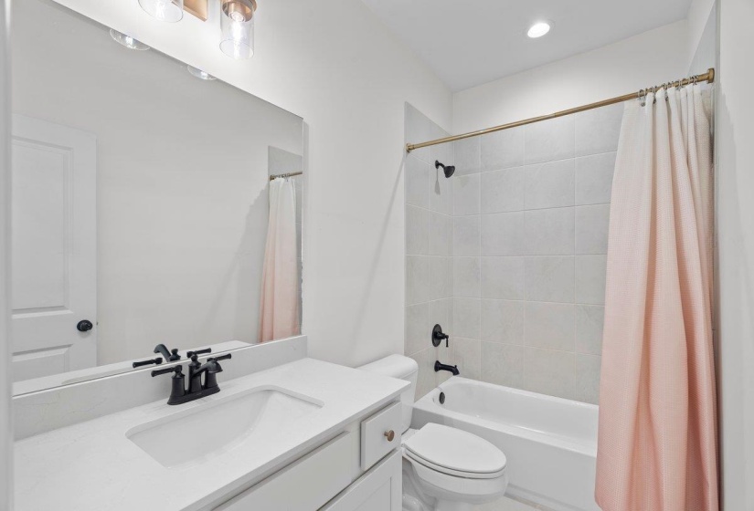 Bathroom featuring vanity, shower / tub combo, and recessed lighting