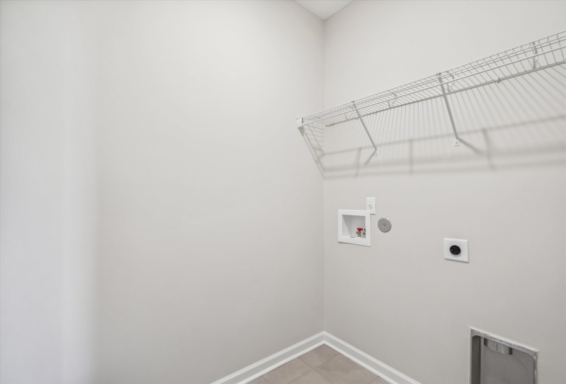 Laundry area featuring hookup for a washing machine, hookup for an electric dryer, and light tile patterned floors