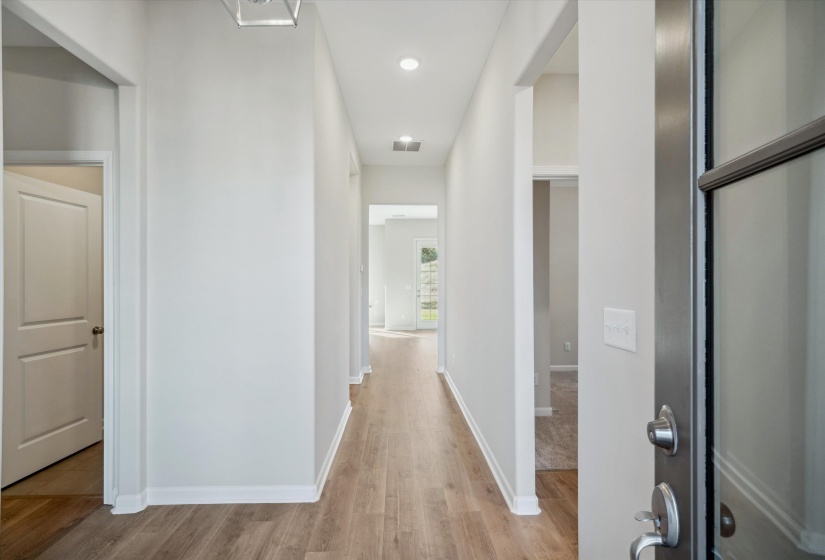 Corridor with light wood-type flooring and recessed lighting